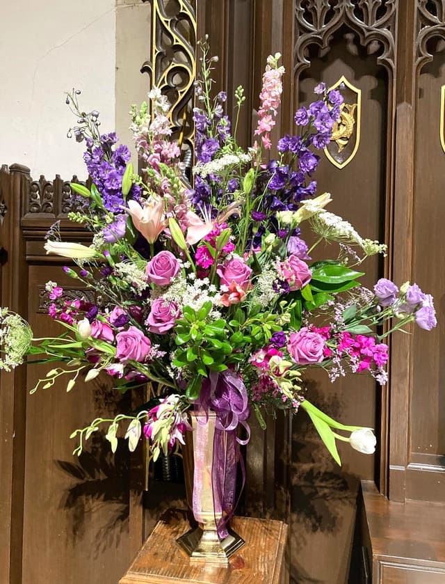 Tall church urn arrangement of purple, pink, and white flowers