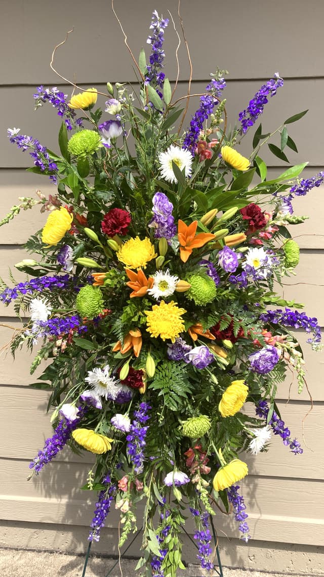 Standing easel spray of yellow, purple, and red flowers