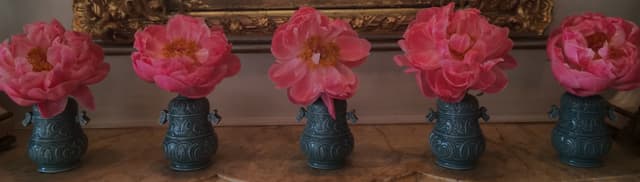 Mantel styled with coral peonies in an antique urn