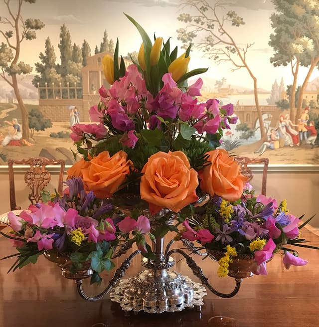 Antique epergne tower filled with orange roses and garden flowers