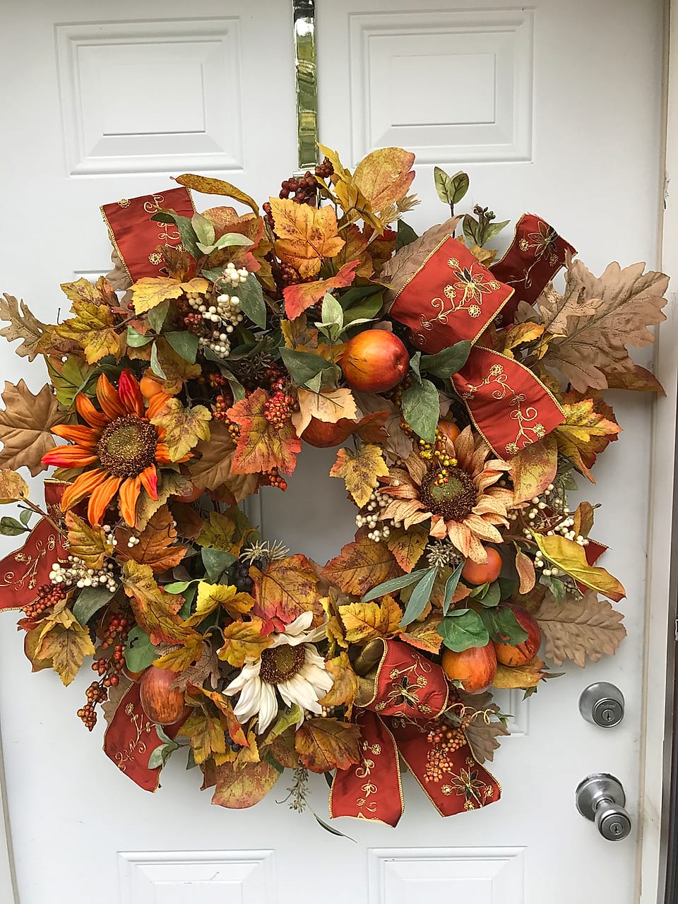 Autumn door wreath of fall leaves, apples, and berries