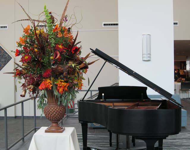 Grand fall arrangement beside a piano for a concert
