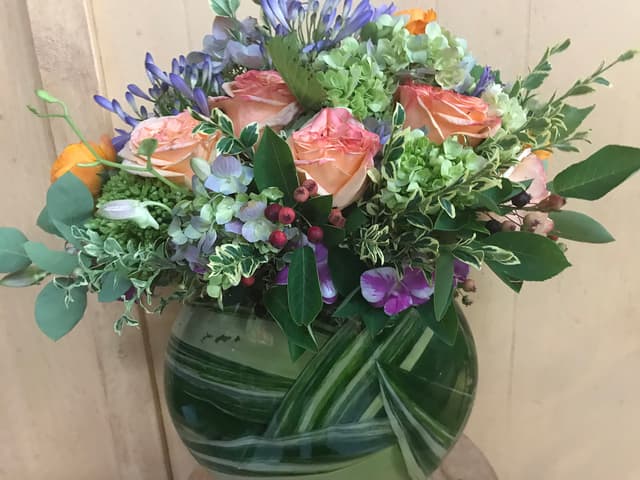 Contemporary design with a leaf submerged under water and pastel roses above