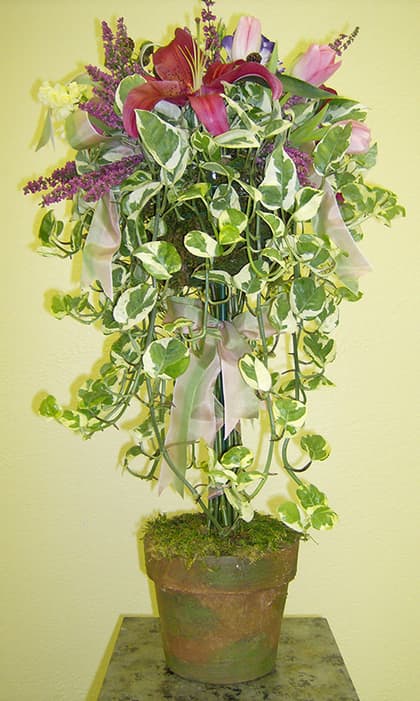 Trailing ivy topiary with lilies and ribbon