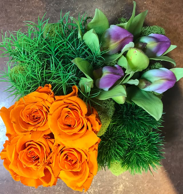 Preserved orange roses paired with purple and green silk accents