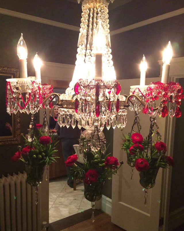 Crystal chandelier dressed with red ranunculus for an event