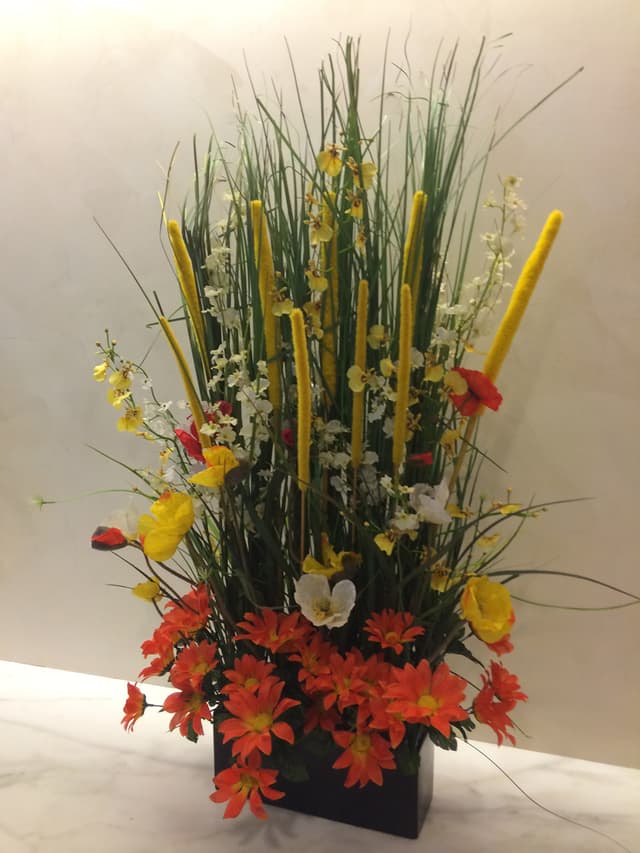 Summer silk arrangement of cattails, daisies, and fall-toned flowers