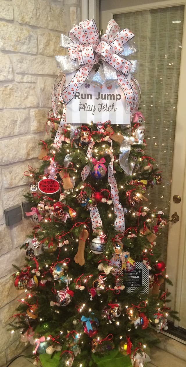 Dog-themed Christmas tree with plush puppy ornaments and ribbon