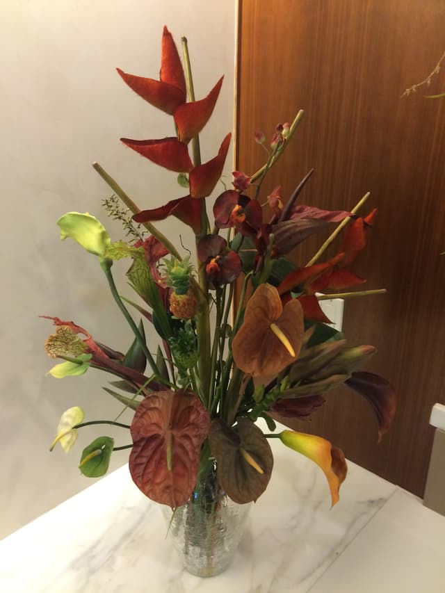 Tropical silk arrangement of heliconia, anthurium, and calla lilies